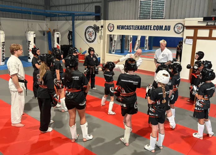 Karate students learning kicks during training with an instructor in Newcastle dojo