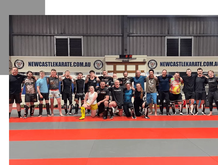 Martial arts group poses together on mats after training at Newcastle Karate