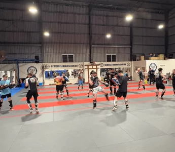 Kickboxing class with adults practising sparring techniques in Newcastle dojo