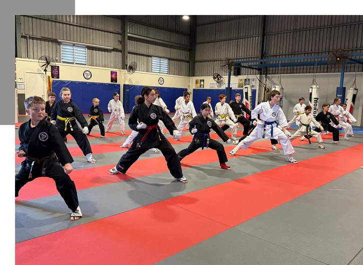Group karate training session with students in uniforms performing stances